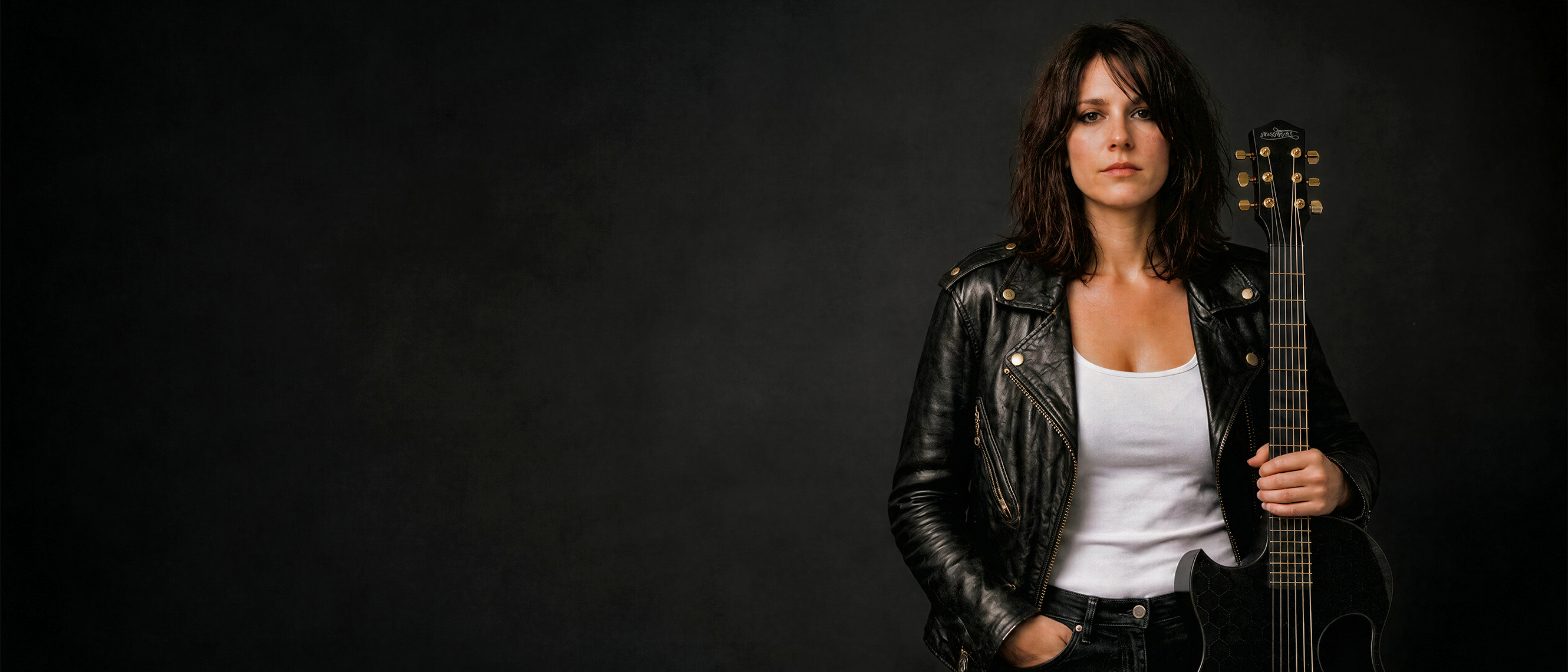 Rock Star standing to one dise against a plain dark background